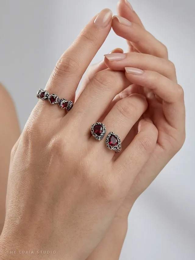 Después, estudio: mano de modelo creada con IA con los mismos dos anillos de plata sobre fondo gris claro