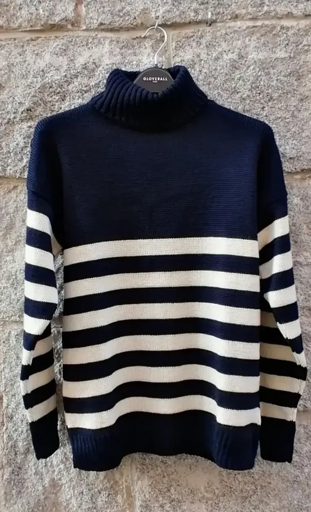Foto original: jersey azul marino de rayas color crudo con cuello vuelto, colgado en una percha
