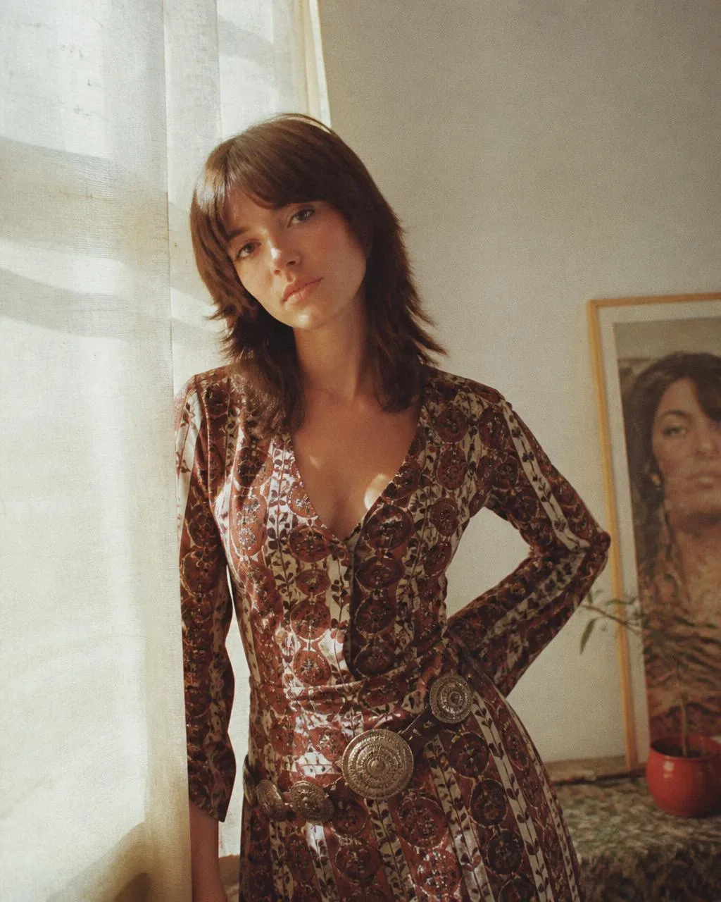 Modelo creada con IA con vestido estampado de inspiración retro junto a una ventana con luz suave